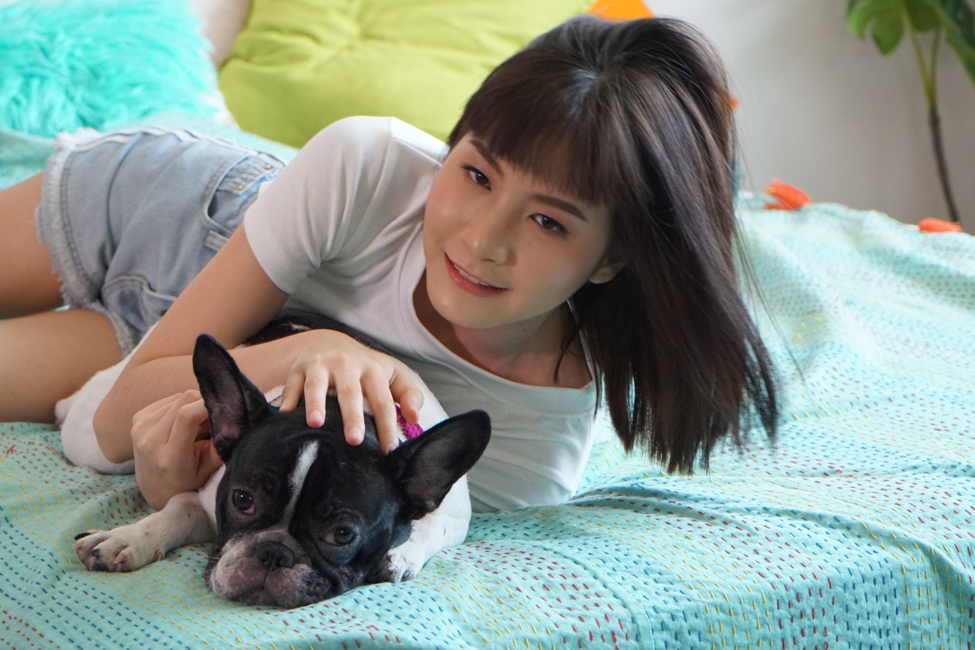 Portrait Of Woman With Dog Lying On Bed At Home